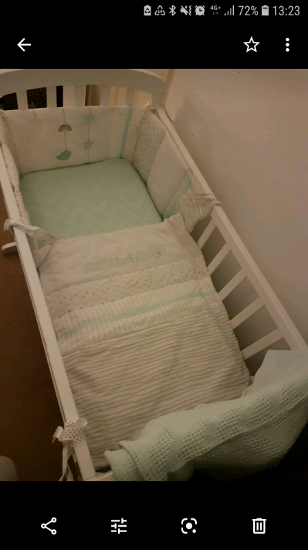 white swinging crib with drapes